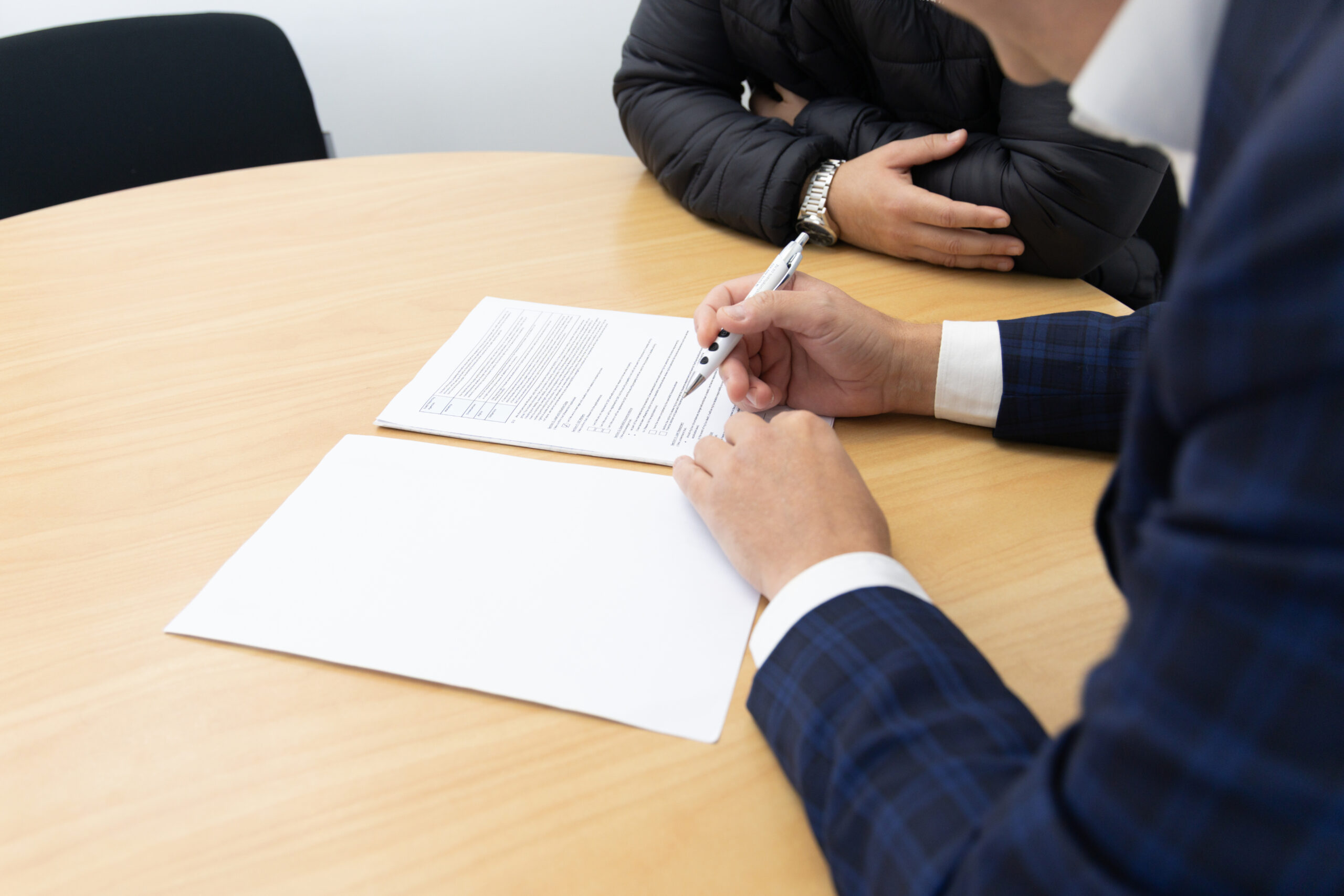 Two people signing documents at a table