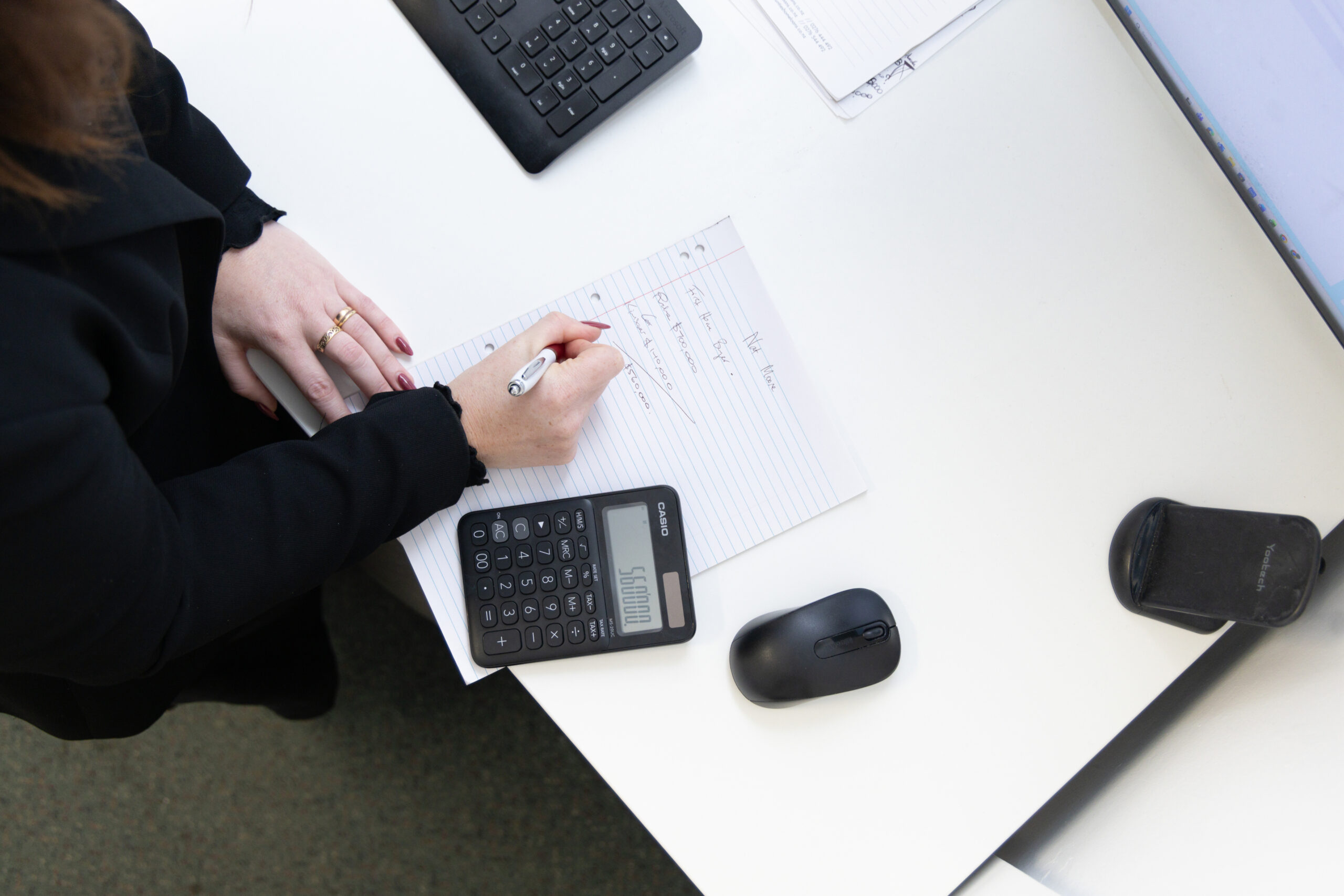 Hands using a calculator over paperwork