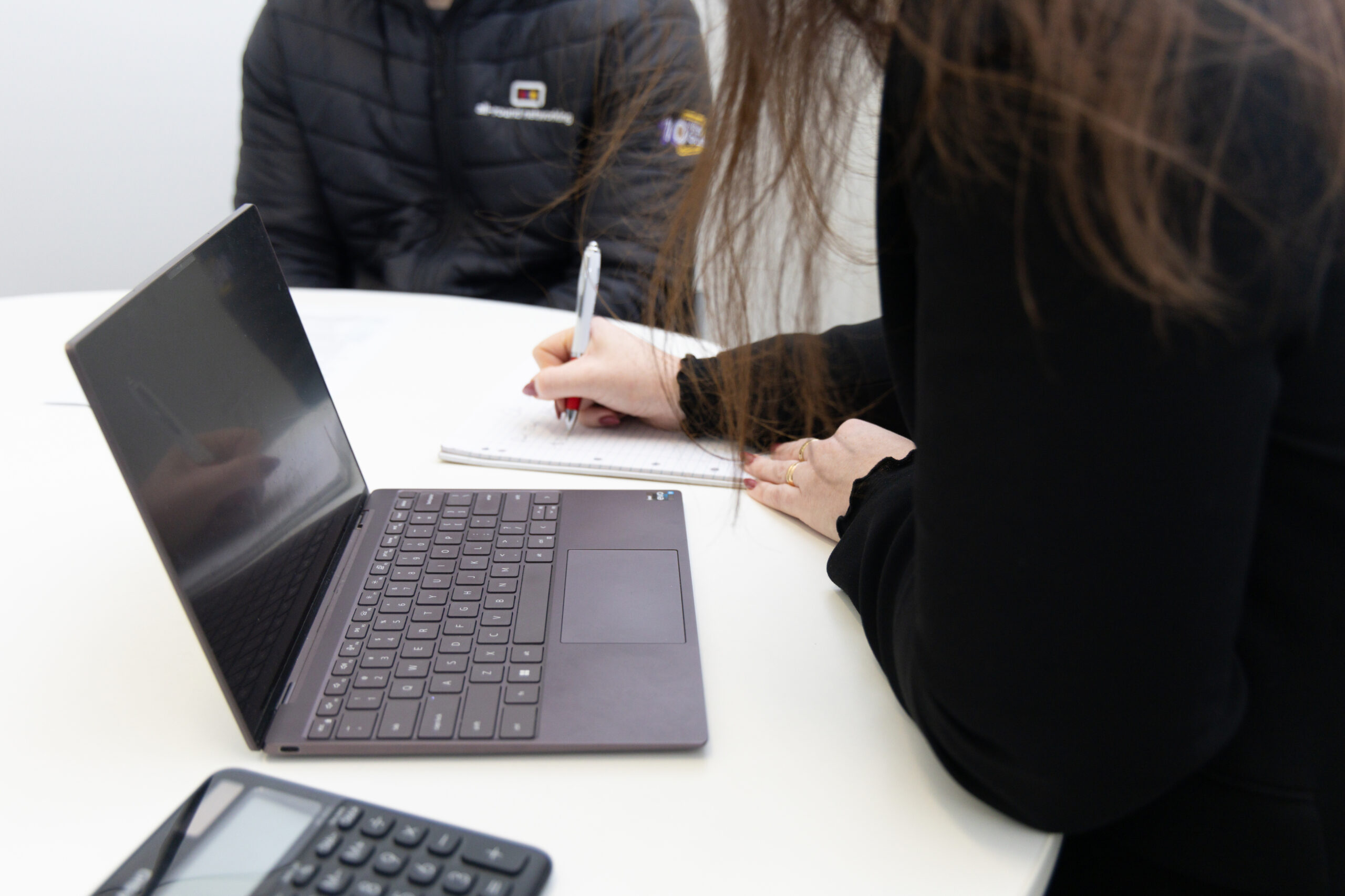 Two people reviewing documents at a des